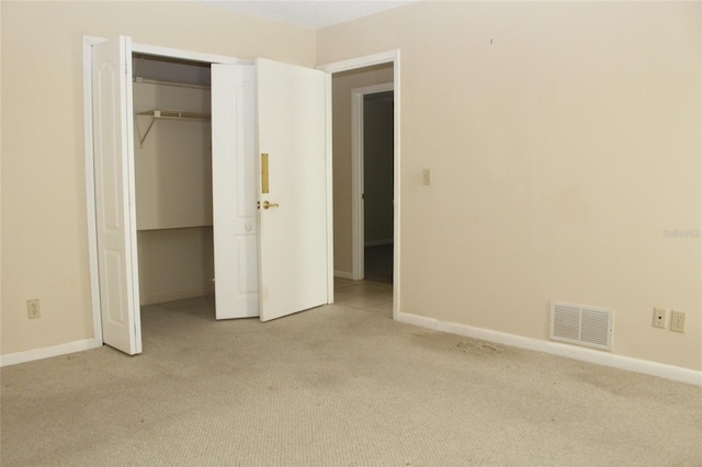 unfurnished bedroom with visible vents, baseboards, and carpet