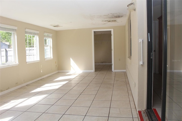 empty room with light tile patterned floors and baseboards