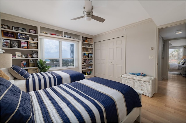 2967 S Atlantic Ave Unit 301, Daytona Beach Shores, FL 32118 - bedroom featuring light wood finished floors, a closet, a ceiling fan, and ornamental molding
