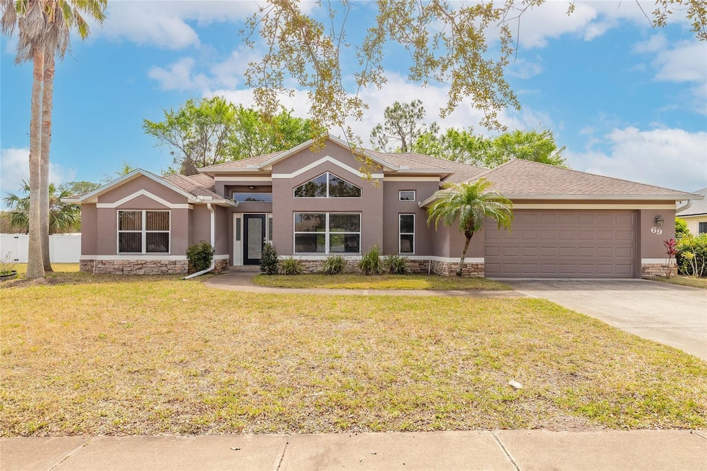 69 Grey Dapple Way, Ormond Beach, FL 32174 - mid-century modern home with stone siding, stucco siding, and a front yard