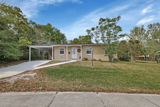 ranch-style house featuring a front lawn, a carport, stucco siding, and concrete driveway