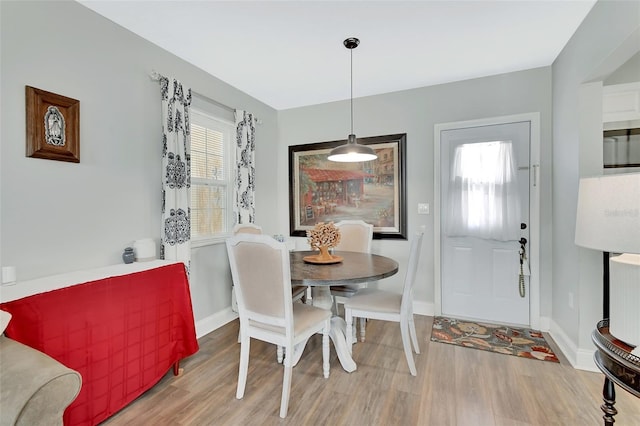 dining space with baseboards and wood finished floors