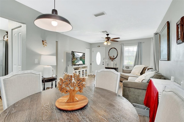 dining space featuring visible vents, wood finished floors, and a ceiling fan