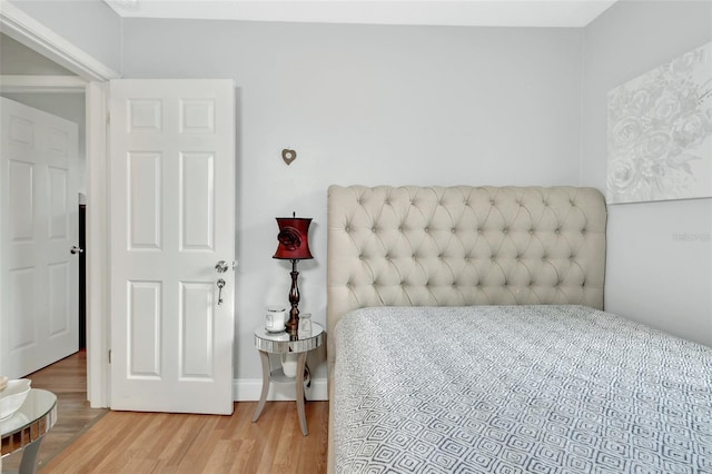 bedroom featuring baseboards and wood finished floors