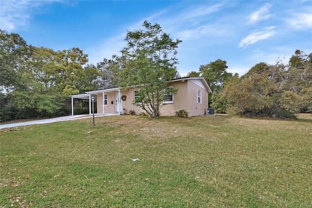 view of front of property with cooling unit, an attached carport, concrete driveway, and a front lawn