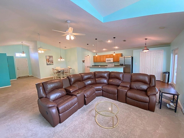 living area with a ceiling fan, a textured ceiling, lofted ceiling, baseboards, and light colored carpet