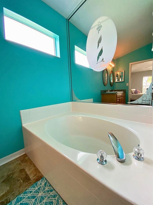 full bathroom featuring a garden tub and vanity