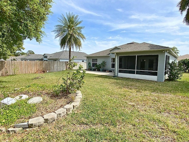 rear view of property featuring a fenced backyard, stucco siding, a sunroom, and a yard