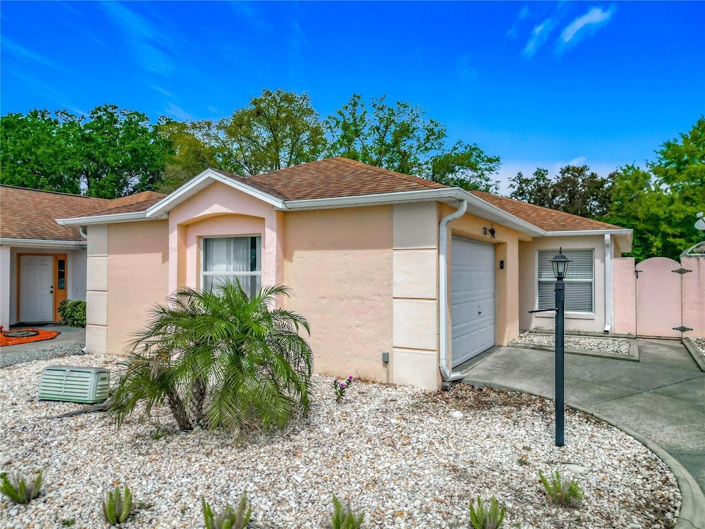 1711 Francisco St, The Villages, FL 32159 - view of front of property with a shingled roof, a gate, stucco siding, and an attached garage