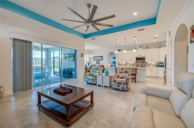 418 Aquamarine Way, Daytona Beach, FL 32124 - living room featuring a raised ceiling, a ceiling fan, light tile patterned floors, visible vents, and arched walkways