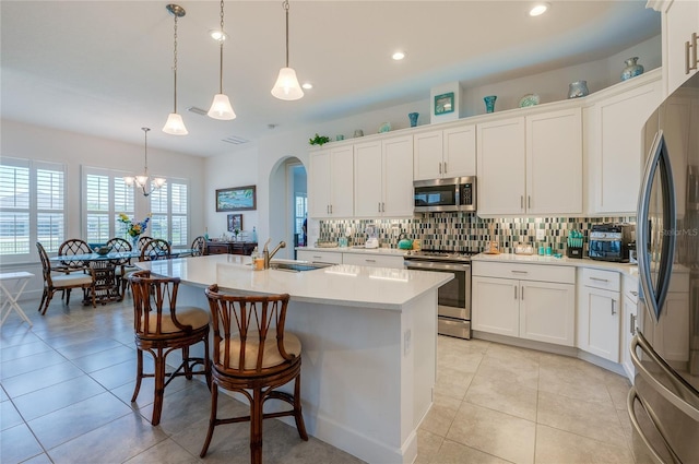 418 Aquamarine Way, Daytona Beach, FL 32124 - kitchen with light countertops, a sink, backsplash, appliances with stainless steel finishes, and white cabinets