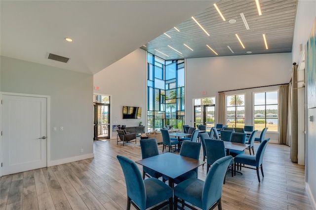 418 Aquamarine Way, Daytona Beach, FL 32124 - dining space featuring baseboards, light wood-type flooring, visible vents, and a towering ceiling