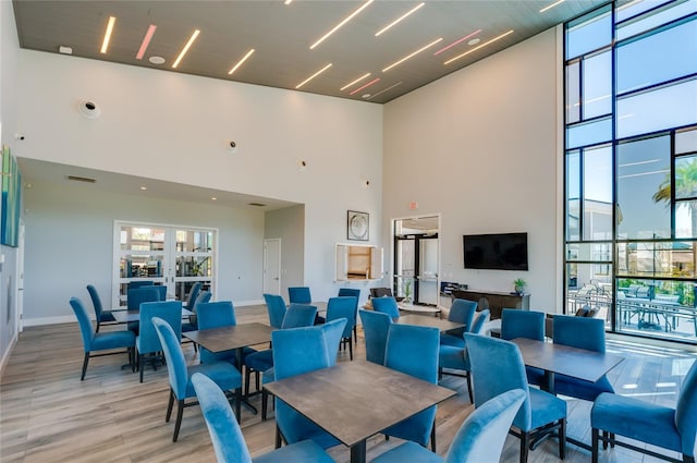 418 Aquamarine Way, Daytona Beach, FL 32124 - dining room featuring baseboards, floor to ceiling windows, a high ceiling, visible vents, and light wood-style flooring