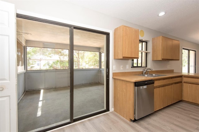 35 Brockton Ln, Palm Coast, FL 32137 - kitchen with stainless steel dishwasher, a sink, plenty of natural light, light wood-style flooring, and a textured ceiling