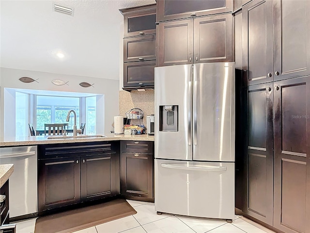 1578 Stone Trl, Deltona, FL 32725 - kitchen with stainless steel appliances, light tile patterned flooring, light stone counters, and dark brown cabinetry