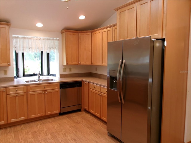 kitchen featuring light countertops, a sink, light wood finished floors, light brown cabinets, and appliances with stainless steel finishes