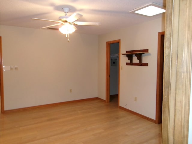 empty room with baseboards, light wood-style flooring, and a ceiling fan