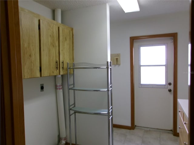 laundry area featuring baseboards, hookup for an electric dryer, and cabinet space