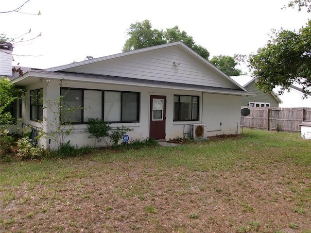 back of property featuring ac unit, fence, and a yard