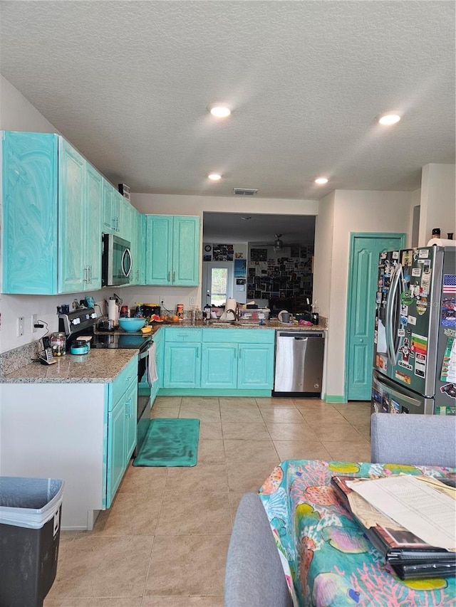 209 Meghan Cir, Deland, FL 32724 - kitchen featuring stainless steel appliances, blue cabinetry, recessed lighting, a textured ceiling, and light tile patterned flooring