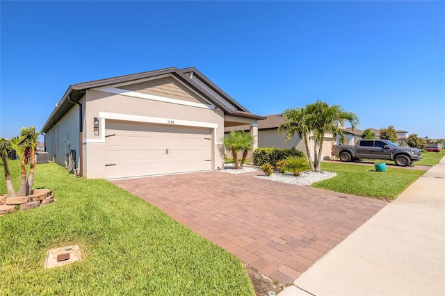 3128 Crab Trap Dr, New Smyrna Beach, FL 32168 - ranch-style home featuring decorative driveway, a front lawn, an attached garage, and stucco siding