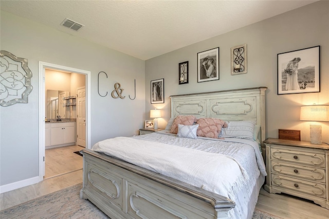 3128 Crab Trap Dr, New Smyrna Beach, FL 32168 - bedroom with light wood-type flooring, connected bathroom, and baseboards