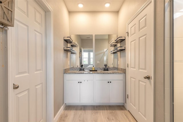 3128 Crab Trap Dr, New Smyrna Beach, FL 32168 - full bathroom with double vanity, wood finished floors, and baseboards