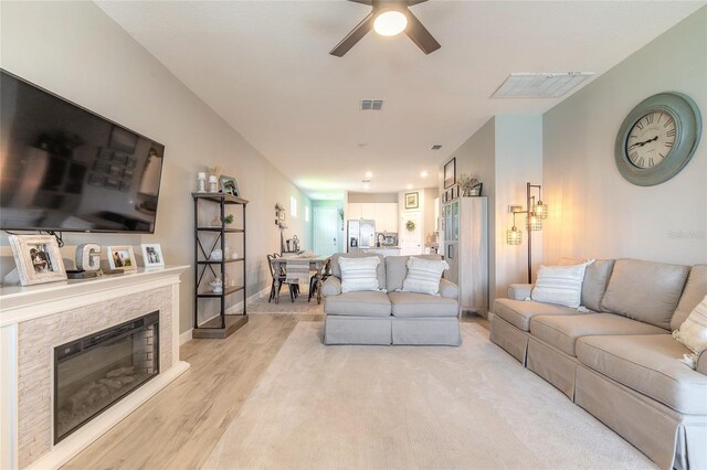 3128 Crab Trap Dr, New Smyrna Beach, FL 32168 - living area with ceiling fan, light wood finished floors, baseboards, and a stone fireplace