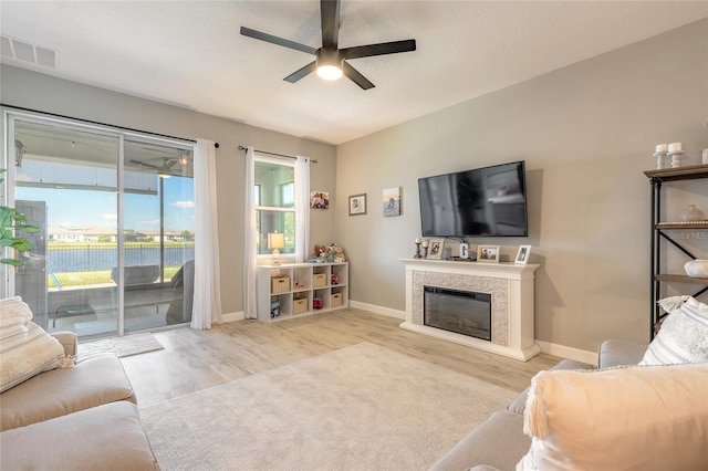 3128 Crab Trap Dr, New Smyrna Beach, FL 32168 - living area featuring ceiling fan, wood finished floors, a glass covered fireplace, and baseboards