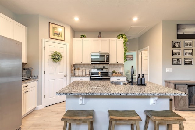 3128 Crab Trap Dr, New Smyrna Beach, FL 32168 - kitchen with stainless steel appliances, backsplash, light wood-style flooring, a sink, and a kitchen bar