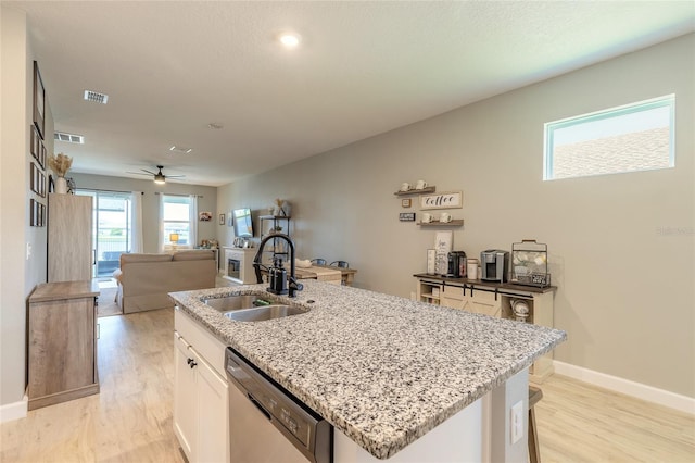 3128 Crab Trap Dr, New Smyrna Beach, FL 32168 - kitchen with stainless steel dishwasher, a sink, light wood-style flooring, open floor plan, and a kitchen island with sink