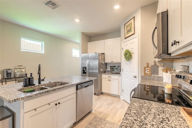 3128 Crab Trap Dr, New Smyrna Beach, FL 32168 - kitchen featuring appliances with stainless steel finishes, a sink, decorative backsplash, white cabinetry, and recessed lighting