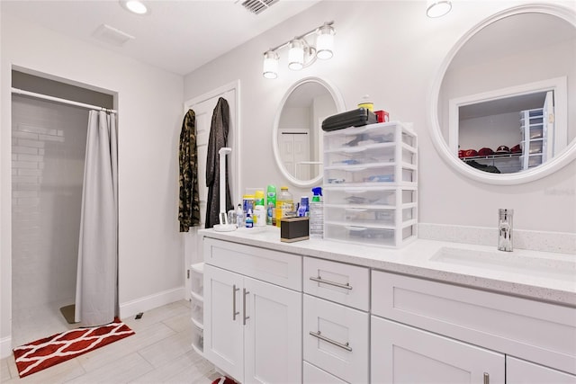 bathroom with double vanity, a sink, and curtained shower