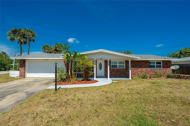 ranch-style house featuring fence, an attached garage, concrete driveway, brick siding, and a front lawn