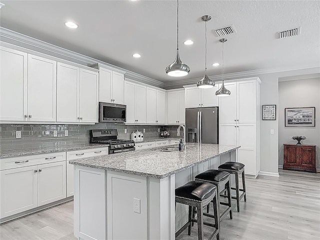 425 Wedgeworth Ln, Deland, FL 32724 - kitchen with white cabinets, appliances with stainless steel finishes, and visible vents