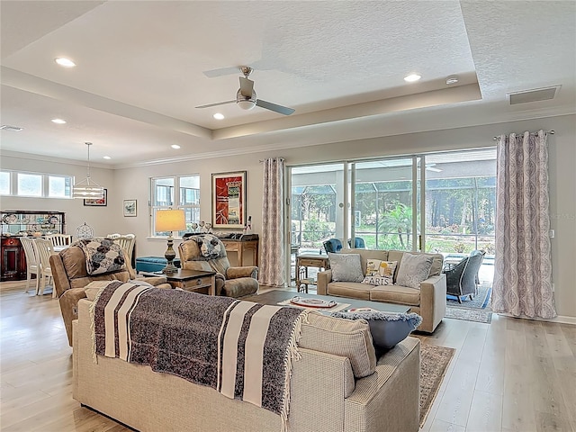425 Wedgeworth Ln, Deland, FL 32724 - living room with a tray ceiling, a textured ceiling, light wood-style floors, visible vents, and a ceiling fan