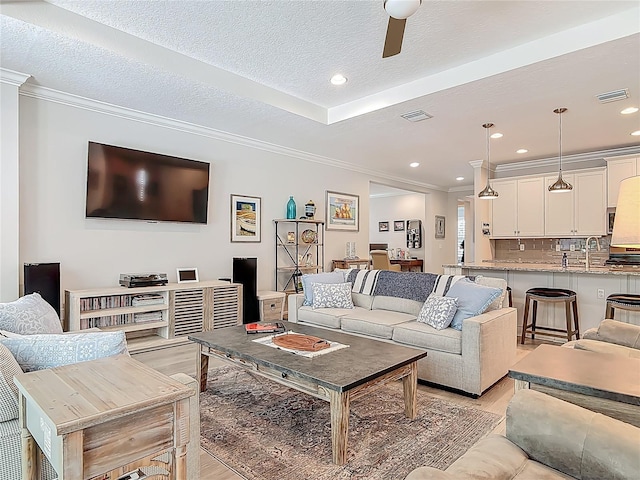 425 Wedgeworth Ln, Deland, FL 32724 - living room with light wood-type flooring, crown molding, a textured ceiling, and visible vents