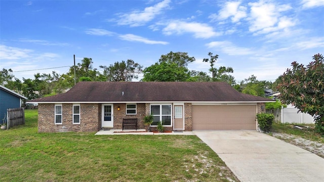 ranch-style house featuring a front yard, an attached garage, fence, and concrete driveway