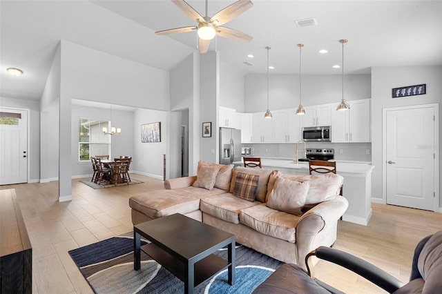1601 Toledo Ave, Deltona, FL 32725 - living room with light wood-style flooring, ceiling fan with notable chandelier, high vaulted ceiling, and visible vents