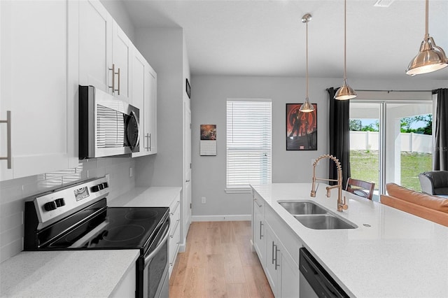 1601 Toledo Ave, Deltona, FL 32725 - kitchen with tasteful backsplash, white cabinets, light wood-style floors, appliances with stainless steel finishes, and a sink