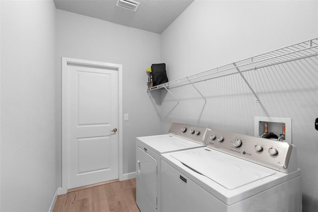 1601 Toledo Ave, Deltona, FL 32725 - clothes washing area featuring visible vents, baseboards, separate washer and dryer, laundry area, and light wood-style flooring