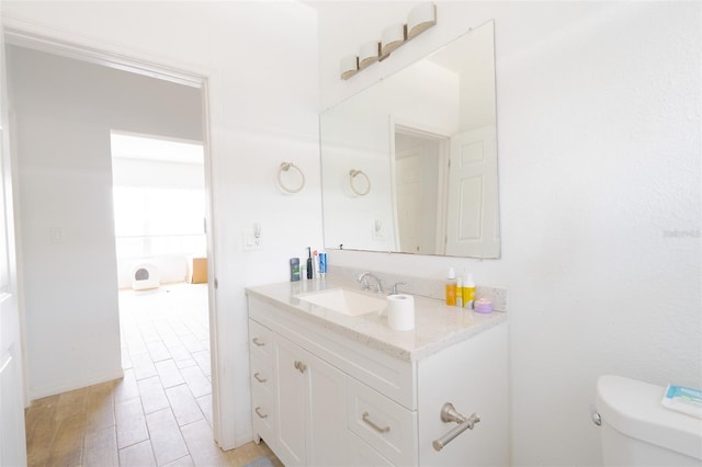 5261 3rd St, Orlando, FL 32810 - bathroom featuring wood finished floors, toilet, and vanity