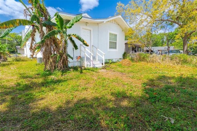 5261 3rd St, Orlando, FL 32810 - view of side of home with stucco siding and a yard