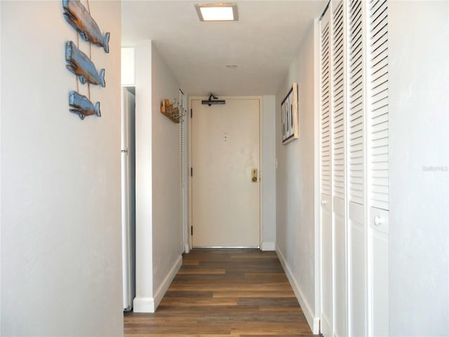 hallway featuring baseboards and wood finished floors