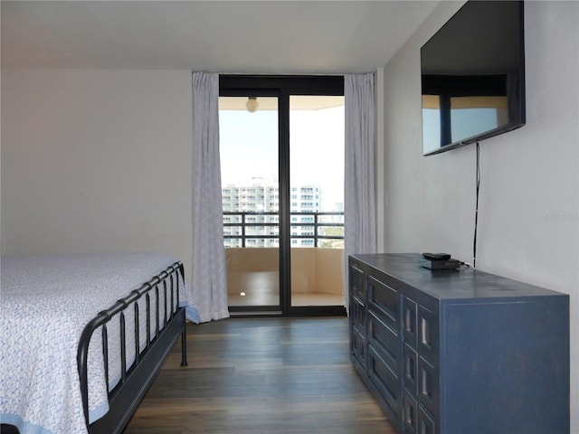 bedroom with a wall of windows, multiple windows, dark wood finished floors, and access to outside