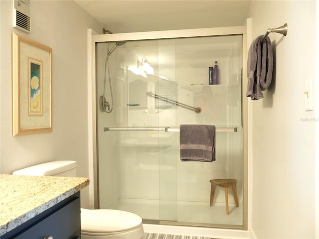 full bath with vanity, a shower stall, toilet, and visible vents