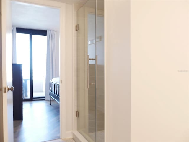 bathroom with a shower stall and wood finished floors