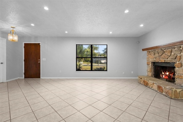 unfurnished living room featuring baseboards, a stone fireplace, recessed lighting, and a textured ceiling