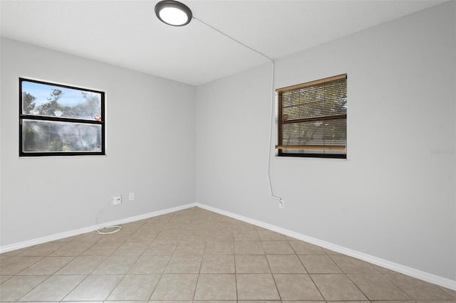unfurnished room featuring baseboards and light tile patterned floors