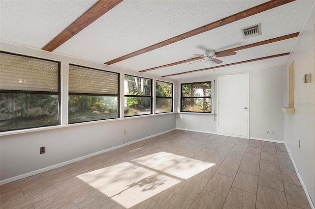 spare room with visible vents, beam ceiling, baseboards, a textured ceiling, and ceiling fan